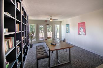 A dining room with a table and chairs and a bookshelf